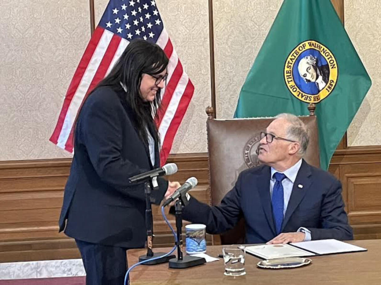 Washington Gov. Jay Inslee, seated, honored Eduardo Carrillo with a special proclamation for his work as the designated &ldquo;bill crier.&rdquo; With a booming voice, Carrillo called out each bill Inslee was about to sign so people who came to watch could make sure they were present.