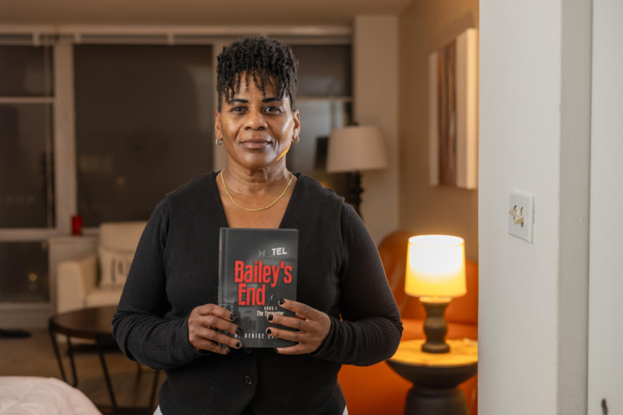 Michelle Conner holds her new book, &ldquo;Bailey&rsquo;s End: Book 1 The Encounter,&rdquo; at home in Chicago on Jan. 24.