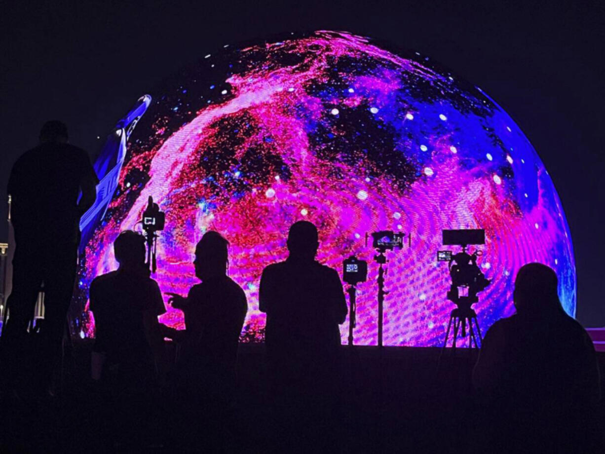 People watch and film Sphere during the Fourth of July unveiling of the Exosphere programming on July 4 in Las Vegas.