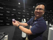 A rep shows off tech device accessories at the Travel Goods Show 2024 in Las Vegas.