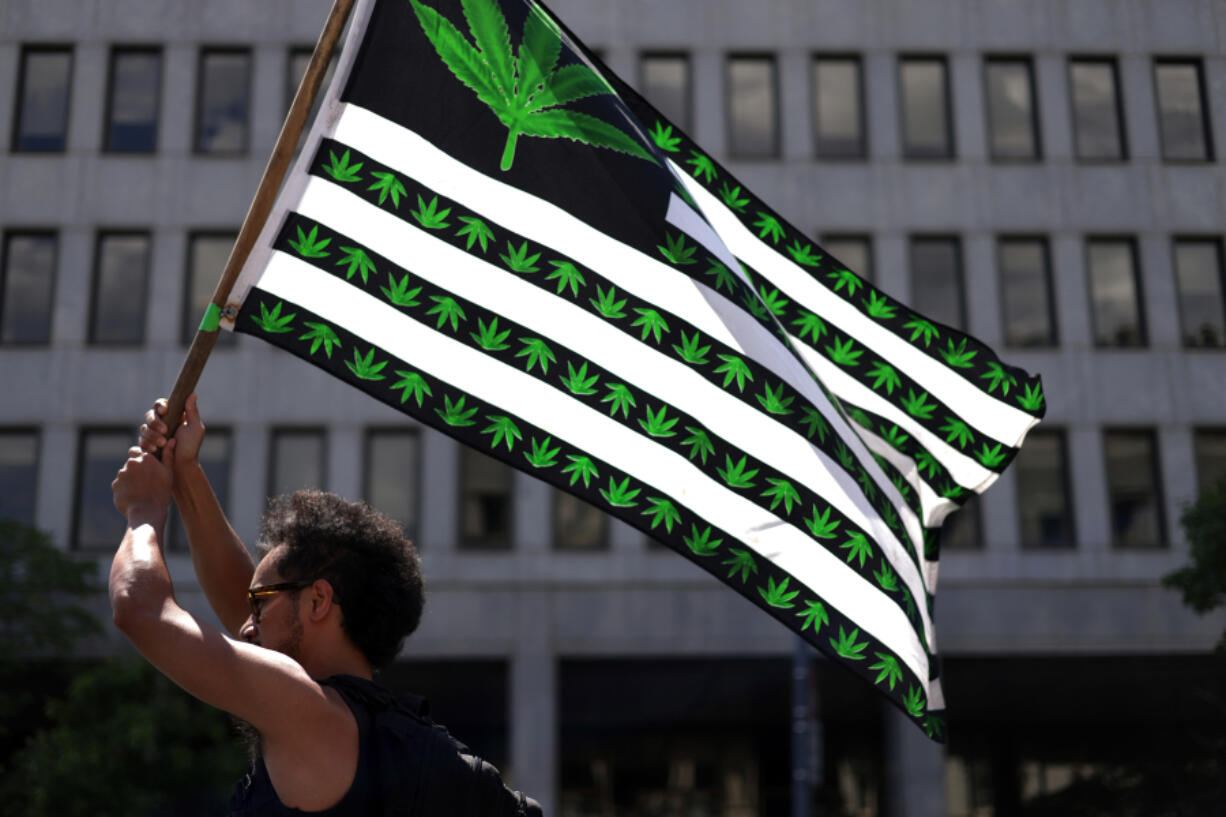A marijuana activist holds a flag during a march on Independence Day on July 4, 2021 in Washington, DC. Members of the group Fourth of July Hemp Coalition gathered outside the White House for its annual protest on marijuana prohibition which the group said it dated back to more than 50 years ago during Nixon Administration.