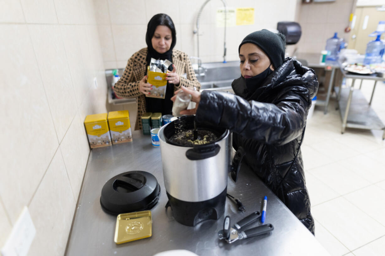 Sam Bawamia, right, and Mona Mahmoud make tea for attendees of an interfaith iftar at the Muslim Education Center in Morton Grove, March 17, 2024.