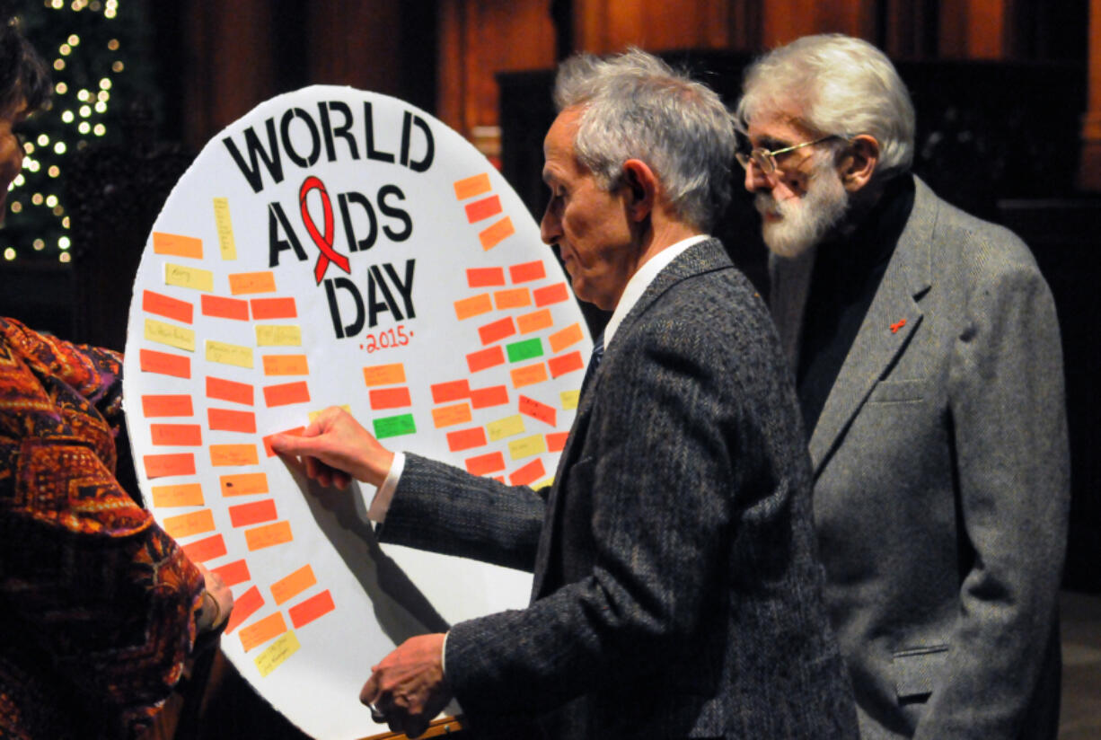 Anthony Silvestre, left, with August Pusateri, contributes to a poster remembering those lost on World AIDS Day in 2015 at Heinz Chapel and sponsored by the Pitt Men&rsquo;s Study.