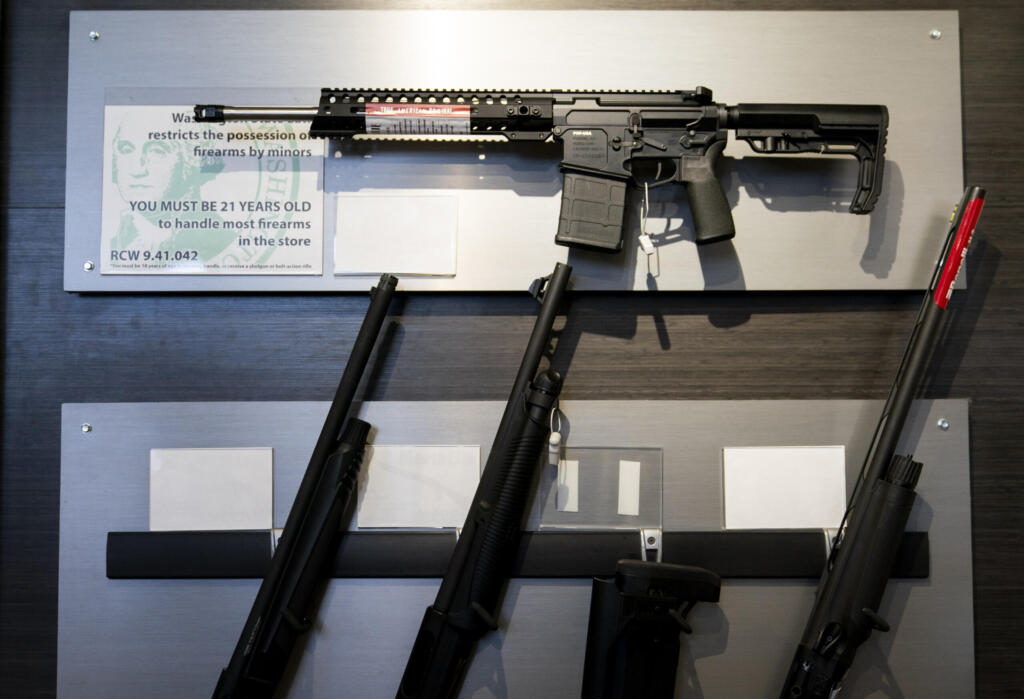 A semi-automatic rifle is displayed above shotguns at Rainier Arms Friday, April 14, 2023, in Auburn, Wash. A Cowlitz County judge ruled Washington’s ban on high-capacity magazines unconstitutional Monday, but just minutes later the state Supreme Court issued an emergency order keeping the law on the books while the state appeals the decision.