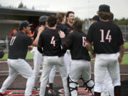 Camas outfielder Jared Forner, center, is mobbed by teammates after hitting a grand slam home run against Battle Ground in the second inning of a 4A Greater St. Helens League baseball game on Thursday, April 11, 2024 at Camas High School.