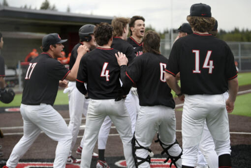 Camas outfielder Jared Forner, center, is mobbed by teammates after hitting a grand slam home run against Battle Ground in the second inning of a 4A Greater St. Helens League baseball game on Thursday, April 11, 2024 at Camas High School.