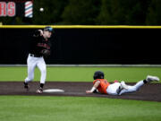 Camas second baseman Cade Lukens, left, throws to first for a double play after forcing out Battle Ground&#039;s Tyler Baldwin in a 4A Greater St. Helens League baseball game on Thursday, April 11, 2024 at Camas High School.