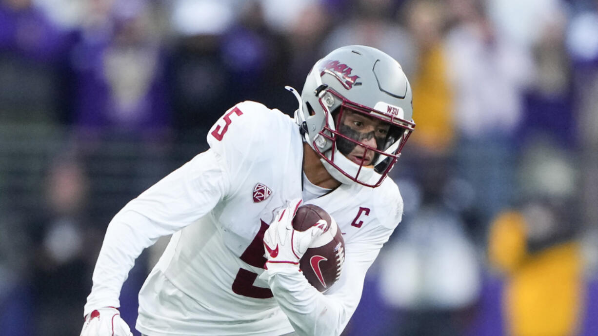 Washington State wide receiver Lincoln Victor (5) carries the ball against Washington during the second half of an NCAA college football game Saturday, Nov. 25, 2023, in Seattle. Washington won 24-21.