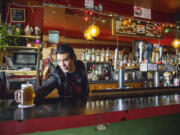 Bar manager Percy Weintraub slides a beer onto the bar for a customer at Al&rsquo;s Tavern in Seattle&rsquo;s Wallingford neighborhood on April 11.