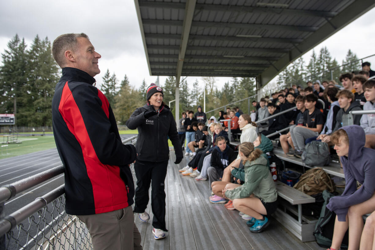 Boys track coach Chris Butler, left, and girls track coach Alisa Wise talk with a packed crowd of athletes before practice Thursday afternoon, March 28, 2024.