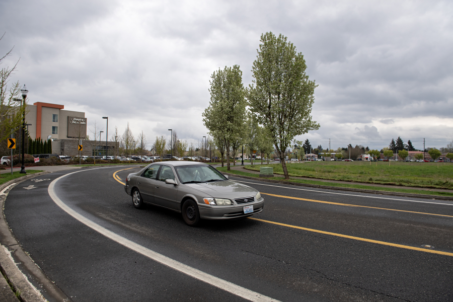 A motorist passes an empty field, right, where a Home2Suites is proposed near Southeast Mill Plain, on Thursday afternoon, April 4, 2024.