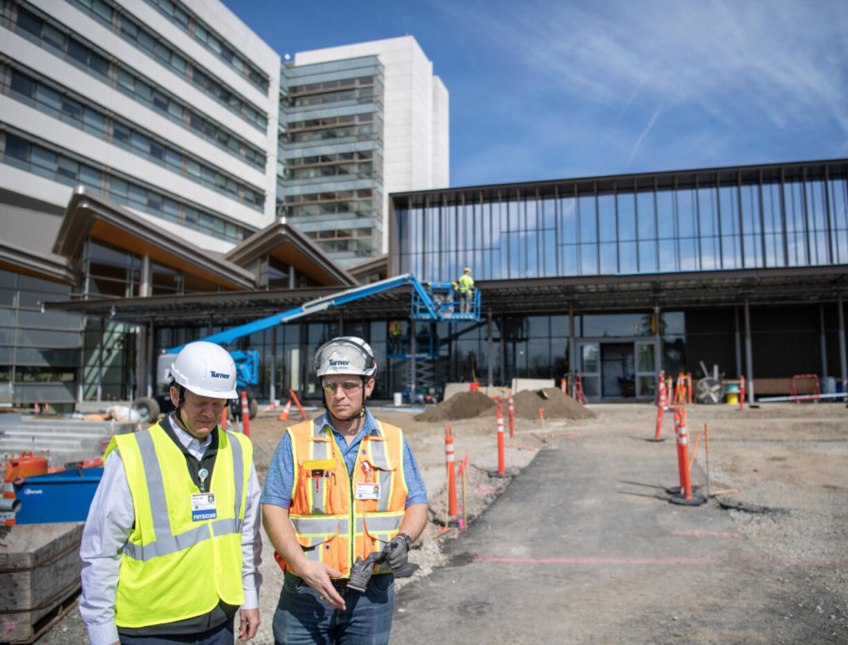Dr. Jason Hanley, left, and site superintendent Joe Newman stand outside of a new emergency department building Friday at PeaceHealth Southwest Medical Center in Vancouver. The first section of the new emergency department is scheduled to open this summer.