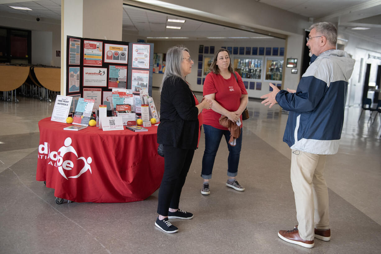 Deborah Alexander, from left, and Jen Barnett, volunteers with Shared Hope International, chat with La Center School District Superintendent Peter Rosenkranz before a presentation about online safety at La Center High School on Wednesday.