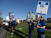 PeaceHealth Southwest Medical Center registered nurse Sarah Collins, right, joins colleagues as they picket outside the hospital on Thursday morning, April 18, 2024.