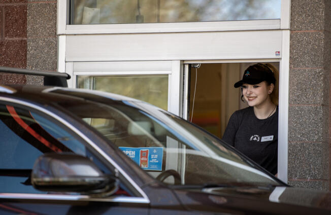 Burgerville crew member Ruby Runnels, 19, greets a customer while working the drive-thru at the restaurant&rsquo;s Salmon Creek location Wednesday afternoon. Several industries in Clark County rely heavily on teens for jobs that peak in demand during the summer. A spokeswoman for Burgerville said the fast-food chain expects to hire 150 additional employees at its Clark County stores between now and July 1.