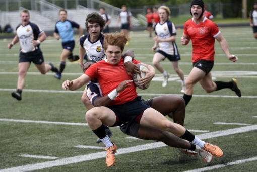 Cruz Williams of the Camas Rugby Club is tackled during a match against Budd Bay of Olympia at Doc Harris Stadium in Camas on Saturday, April 13, 2024. (Tim Martinez/The Columbian)