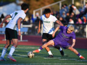Heritage senior Marcos Tobar Martinez, right, pokes the ball away from Evergreen junior Juan Gomez-Rios on Friday, April 19, 2024, during the Timberwolves’ 3-1 win against Evergreen at Heritage High School.