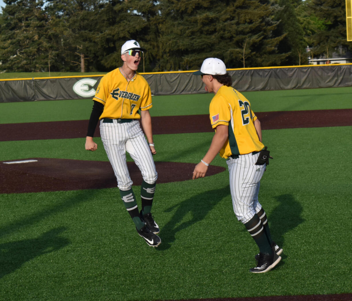 Evergreen players Joey Marin (7) and Ace Gutierrez celebrate the Plainsmen&rsquo;s 4-0 win over Kelso in a 3A Greater St. Helens League baseball game at Evergreen Sports Complex on Monday.