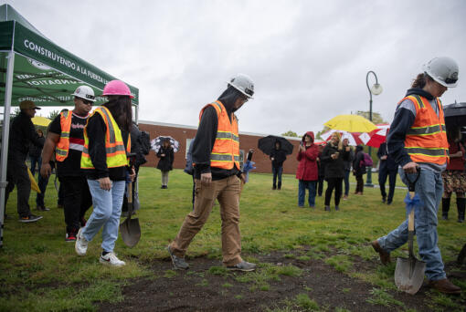 Sophomore Charles Paulin, 15, from left in white helmet, joins junior Aileene Villegas, 17, pink hat, senior Carl Steele, 18, and senior Maxx Van Hoomissen, 18, during the groundbreaking on a new building to support construction trades and maritime pathways for Vancouver students at Hudson&rsquo;s Bay High School on Tuesday morning.
