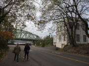 Pedestrians pass the old electrical substation at the foot of the northbound span of the Interstate 5 Bridge. The empty building is listed for sale at $1 million.