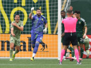 Portland Timbers goalkeeper Maxime Crépeau (16) and Los Angeles FC defender Sergi Palencia (14) run to make their case with head referee Rubiel Vazquez on Saturday, April 13, 2024, during the Timbers’ 2-2 draw against Los Angeles FC at Providence Park in Portland.