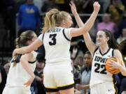 Iowa guard Caitlin Clark (22), guard Sydney Affolter (3) and guard Kate Martin (20) celebrate after defeating LSU in an Elite Eight round college basketball game during the NCAA Tournament, Monday, April 1, 2024, in Albany, N.Y.