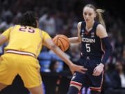 UConn guard Paige Bueckers (5) dribbles the ball as Southern California guard McKenzie Forbes (25) defends during the first half of an Elite Eight college basketball game in the women's NCAA Tournament, Monday, April 1, 2024, in Portland, Ore.