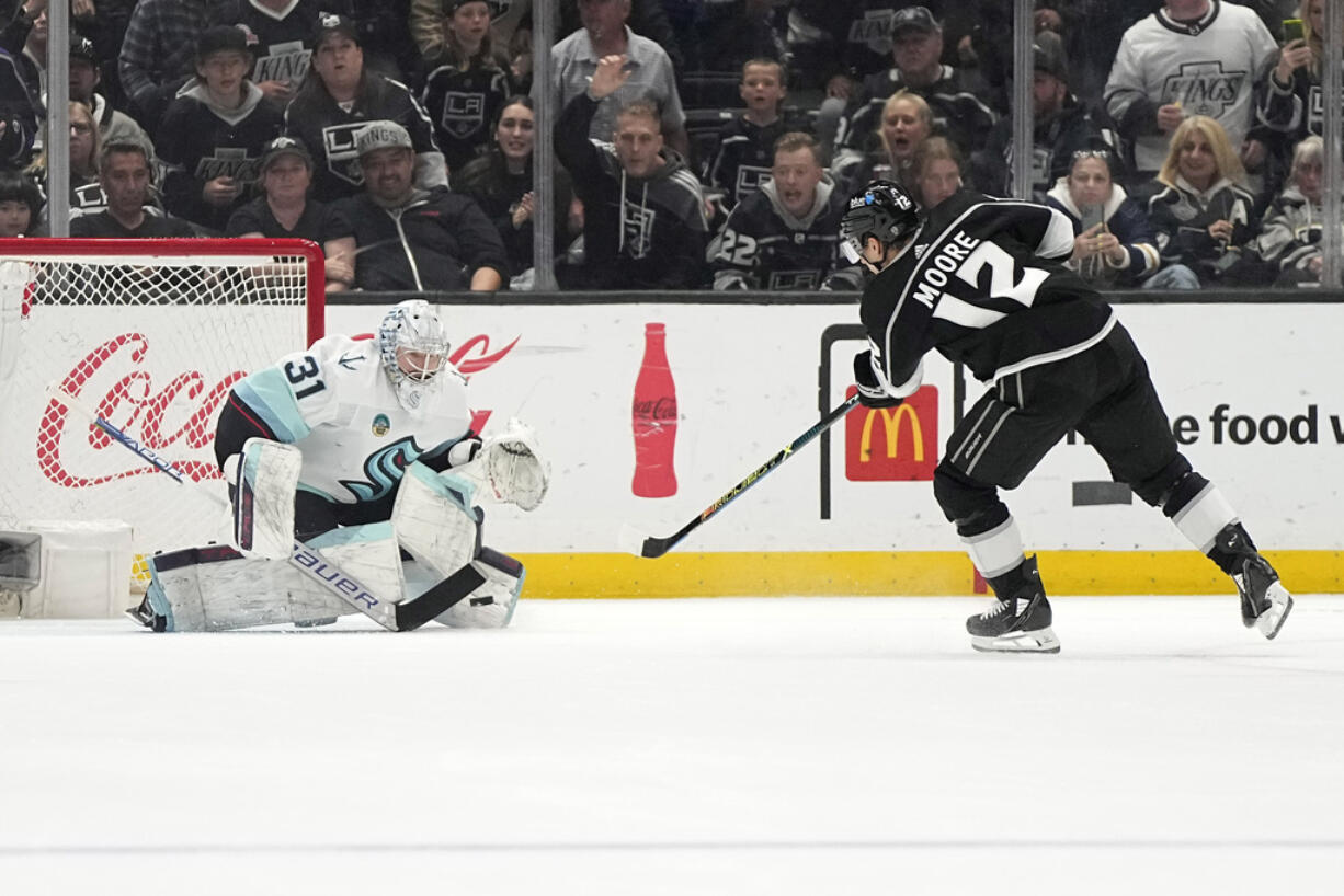 Los Angeles Kings left wing Trevor Moore, right, scores on Seattle Kraken goaltender Philipp Grubauer during the third period of an NHL hockey game Wednesday, April 3, 2024, in Los Angeles. That was Moore's third goal of the game. (AP Photo/Mark J.