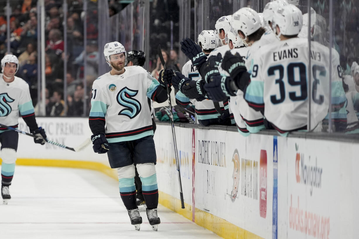 Seattle Kraken center Shane Wright, center left, celebrates after his goal with the bench during the first period of an NHL hockey game against the Anaheim Ducks, Friday, April 5, 2024, in Anaheim, Calif.