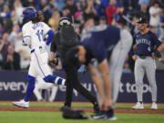 Toronto Blue Jays' Bo Bichette (11) runs the bases after hitting a two-run home run off Seattle Mariners pitcher George Kirby, foreground, during the third inning of a baseball game Tuesday, April 9, 2024, in Toronto.