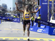Sisay Lemma, of Ethiopia, breaks the tape to win the Boston Marathon, Monday, April 15, 2024, in Boston.