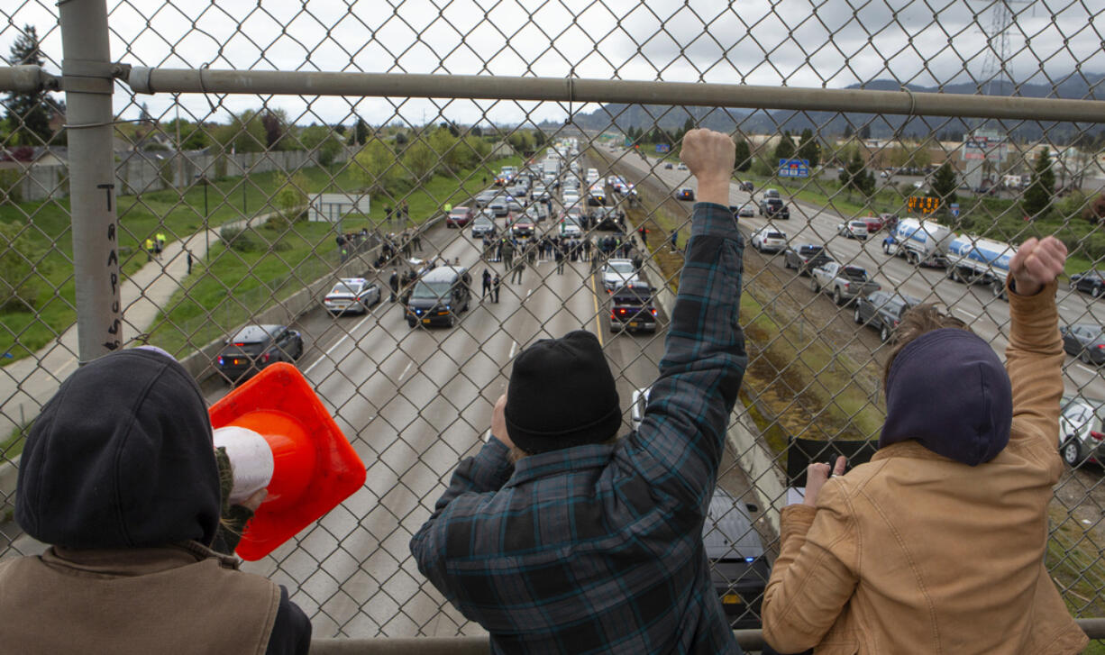 Anti-Israel Protesters cheer on others from the Harlow Road overpass as others block the south bound lane of Interstate 5 between Eugene, Ore., and Springfield below on Monday, April 15, 2024.