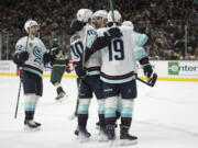 Seattle Kraken center Matty Beniers (10) celebrates his goal against the Minnesota Wild with teammates during the second period of an NHL hockey game Thursday, April 18, 2024, in St. Paul, Minn.