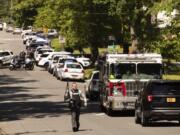 Multiple law enforcement vehicles respond in the neighborhood where several officers on a task force trying to serve a warrant were shot in Charlotte, N.C., Monday, April 29, 2024.