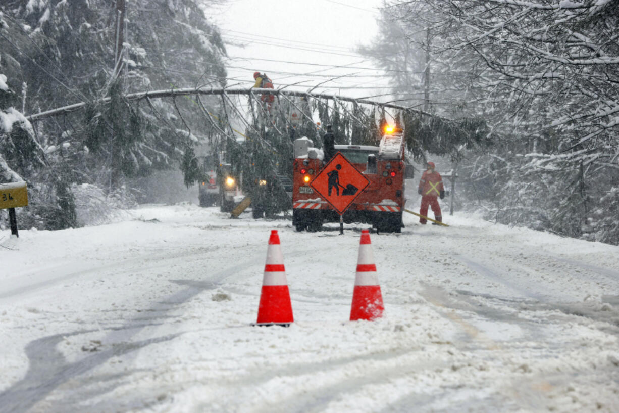 A portion of Route 9 between Falmouth and Cumberland is closed as crews work to remove a downed tree spanning the snow-covered roadway in Falmouth, Maine, Thursday, April 4, 2024, following a spring snowstorm.