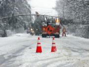 A portion of Route 9 between Falmouth and Cumberland is closed as crews work to remove a downed tree spanning the snow-covered roadway in Falmouth, Maine, Thursday, April 4, 2024, following a spring snowstorm.