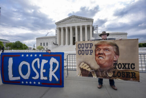 Activist Stephen Parlato of Boulder, Colo., right, joins other protesters outside the Supreme Court as the justices prepare to hear arguments over whether Donald Trump is immune from prosecution in a case charging him with plotting to overturn the results of the 2020 presidential election, on Capitol Hill in Washington, Thursday, April 25, 2024. (AP Photo/J.