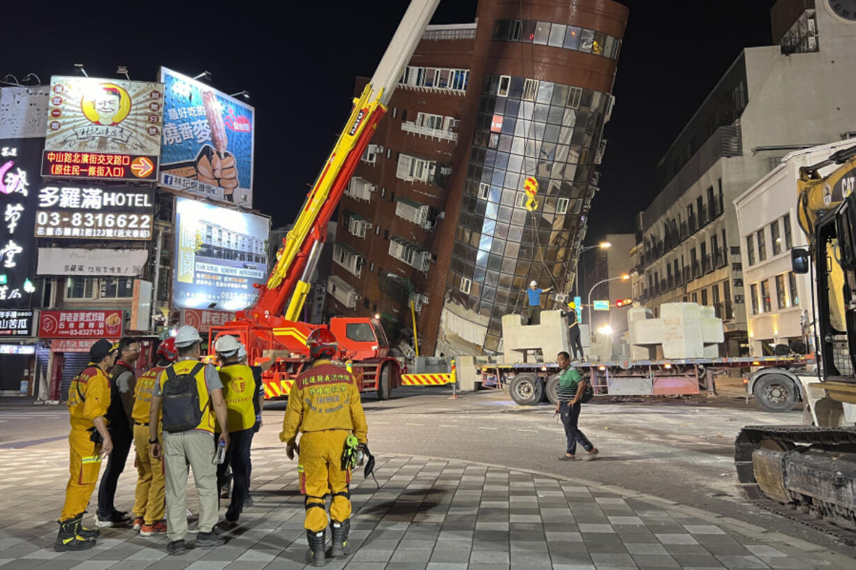 Rescue workers stand near the site of a leaning building in the aftermath of an earthquake in Hualien, Taiwan, on Wednesday, April 3, 2024. Taiwan&rsquo;s strongest earthquake in a quarter century rocked the island during the morning rush hour Wednesday.