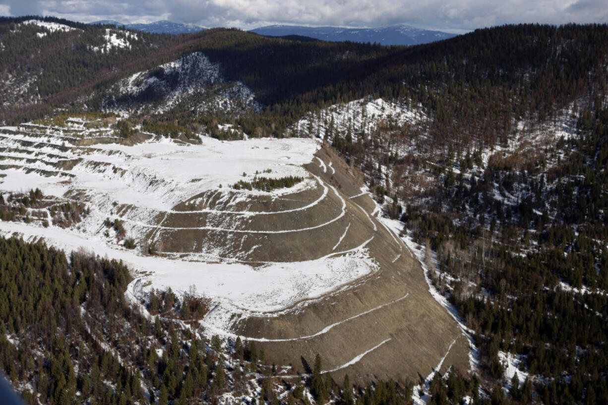 FILE - The W.R. Grace vermiculite mine is shown, outside of Libby, Mont., Feb. 17, 2010. Libby, a town of about 3,000 along the Kootenai River, had widespread contamination from asbestos-tainted vermiculite that was stored in town and transported by rail across the U.S. for use as insulation and other purposes. Contamination in the town has been cleaned up but the mine has not been addressed.
