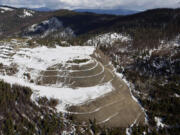 FILE - The W.R. Grace vermiculite mine is shown, outside of Libby, Mont., Feb. 17, 2010. Libby, a town of about 3,000 along the Kootenai River, had widespread contamination from asbestos-tainted vermiculite that was stored in town and transported by rail across the U.S. for use as insulation and other purposes. Contamination in the town has been cleaned up but the mine has not been addressed.