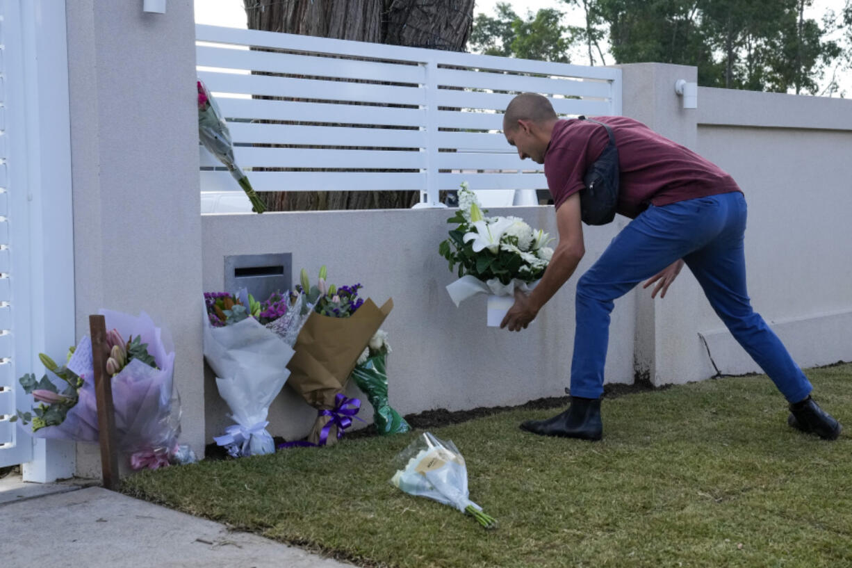 A man places flowers outside the Christ the Good Shepherd church in suburban Wakely in western Sydney, Australia, Tuesday, April 16, 2024. Australian police say a knife attack in Sydney that wounded a bishop and a priest during a church service as horrified worshippers watched online and in person, and sparked a riot was an act of terrorism.