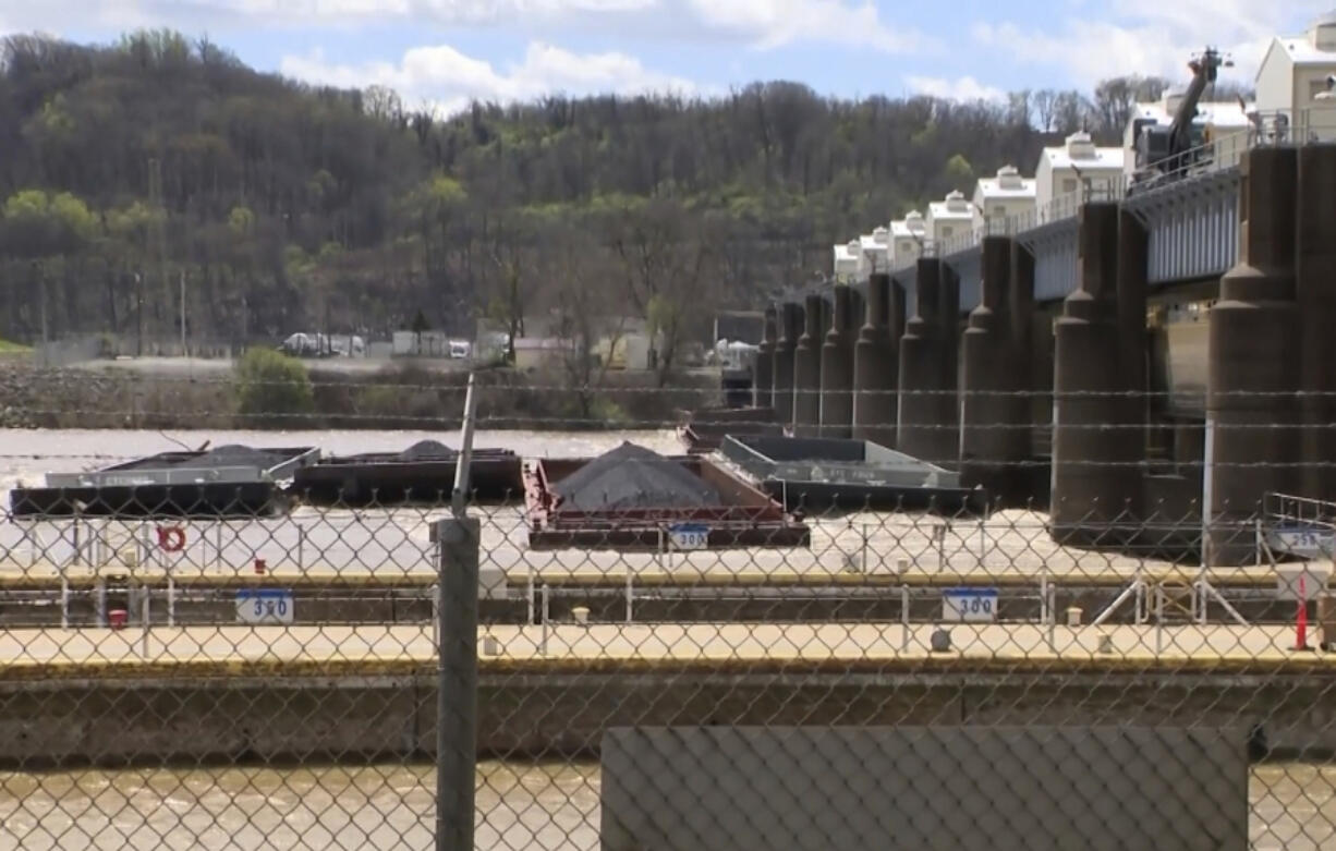 A group of barges sit pinned against the Emsworth lock and dam in Pittsburgh, on Saturday, April 13, 2024. More than two dozen river barges broke loose from their moorings and floated down the Ohio River, damaging a marina and striking a bridge.