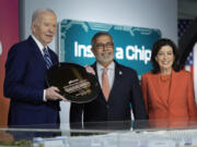 Micron Technology CEO Sanjay Mehrotra, center, presents a plaque to President Joe Biden, left, in honor of Biden&rsquo;s support of Micron through the CHIPS and Science Act, at the Milton J. Rubenstein Museum, Thursday, April 25, 2024, in Syracuse, N.Y. Pictured at right is New York Governor Kathy Hochul.