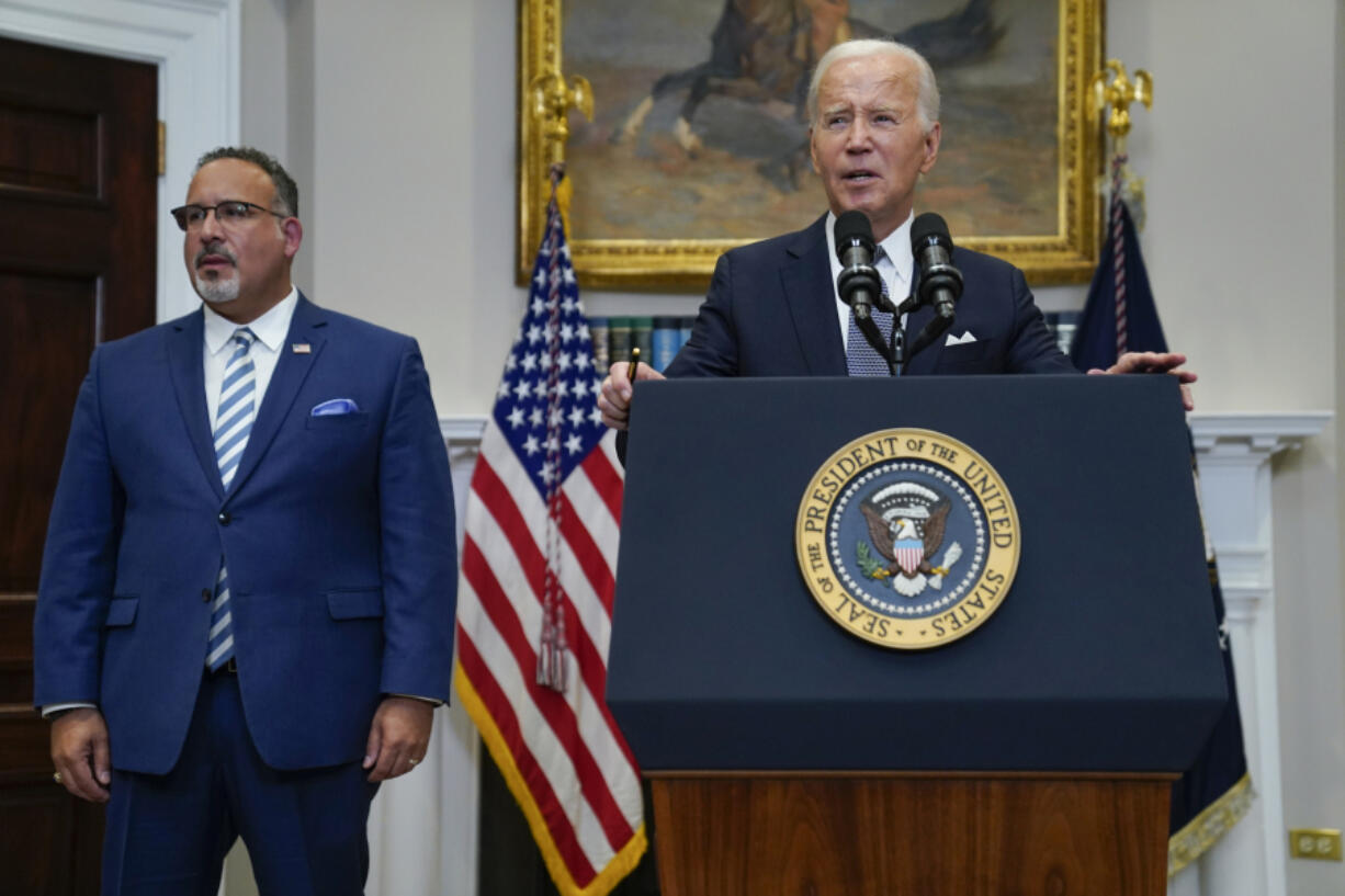 FILE - President Joe Biden speaks as Education Secretary Miguel Cardona listens at the White House, June 30, 2023, in Washington. Biden is traveling to Wisconsin Monday, April 8, 2024, to announce details of a new plan to help millions of people with their student loan debt. Last year, the U.S. Supreme Court foiled Biden&rsquo;s plan to provide hundreds of billions of dollars in student loan debt relief to millions. The visit comes a week after primary voting in the Midwest battleground state highlights weakness for him and Republican challenger Donald Trump.