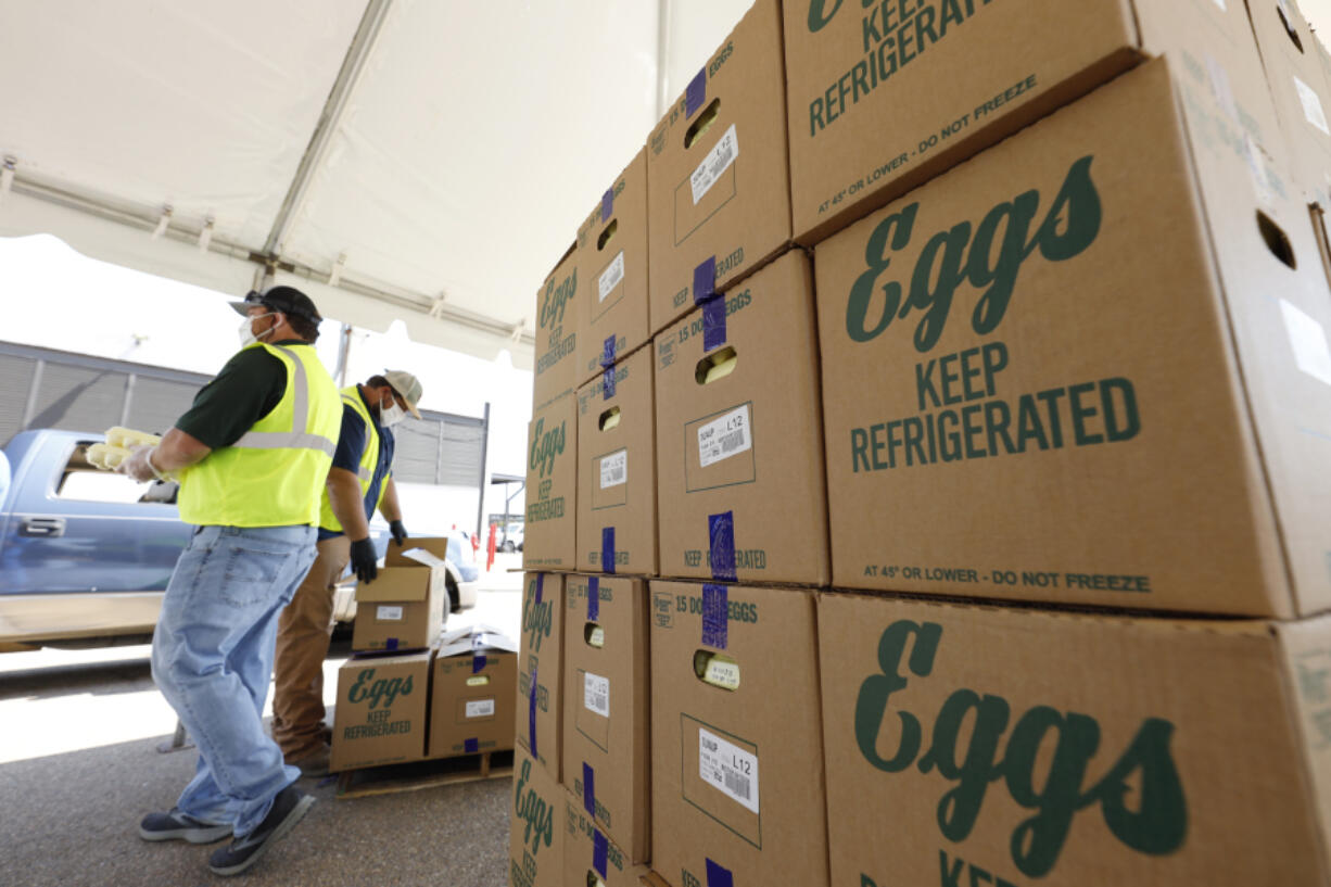 FILE - Cases of eggs from Cal-Maine Foods, Inc., await to be handed out by the Mississippi Department of Agriculture and Commerce employees at the Mississippi State Fairgrounds in Jackson, Miss., on Aug. 7, 2020. The largest producer of fresh eggs in the United States said Tuesday, April 2, 2024 that it has stopped production at a Texas plant after bird flu was found in chickens there. Cal-Maine Foods, Inc. said in a statement that approximately 1.6 million laying hens and 337,000 pullets, about 3.6% of its total flock, were destroyed after the infection, avian influenza, was found at the facility in Parmer County, Texas. (AP Photo/Rogelio V.