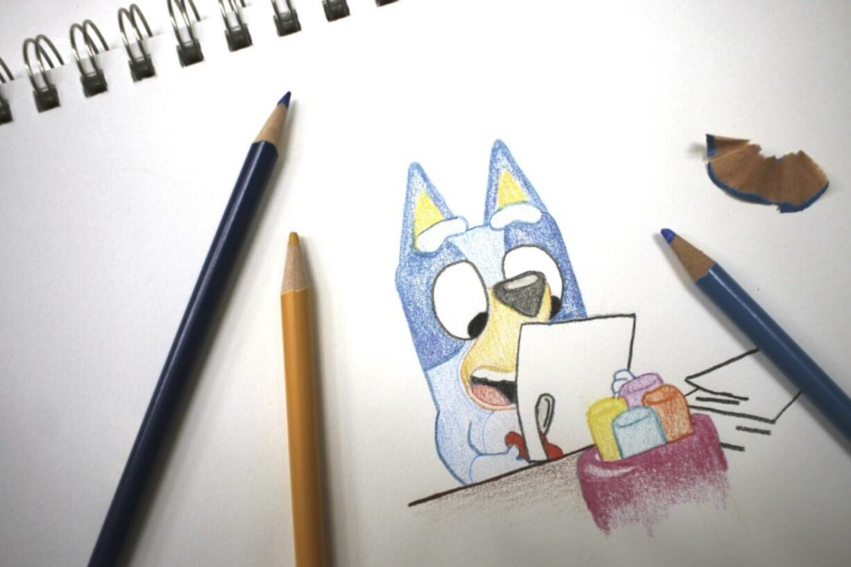 Colored pencils sit around a drawing of &ldquo;Bluey,&rdquo; an Australian kids&rsquo; television program character, on a sketch pad April 19 in Phoenix, Ariz.