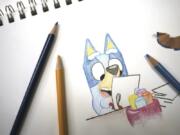 Colored pencils sit around a drawing of &ldquo;Bluey,&rdquo; an Australian kids&rsquo; television program character, on a sketch pad April 19 in Phoenix, Ariz.