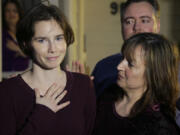FILE - Amanda Knox, left, talks to reporters as her mother, Edda Mellas, right, looks on outside Mellas&#039; home in Seattle, Friday, March 27, 2015. Amanda Knox faces yet another trial for slander in a case that could remove the last remaining guilty verdict against her nine years after Italy&#039;s highest court definitively threw out her conviction for the murder of her 21-year-old British roommate, Meredith Kercher. (AP Photo/Ted S.