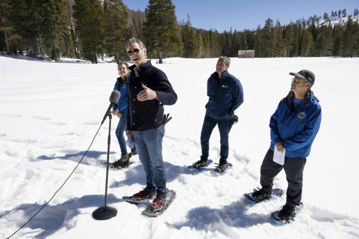 Gov. Gavin Newsom announces an updated California Water Plan with Department of Water Resources director Karla Nemeth, left, Natural Resources Secretary Wade Crowfoot, center, and DWR water resources engineer Andrew Reising during the April snow survey at Phillips Station in El Dorado County on Tuesday, April 2, 2024.