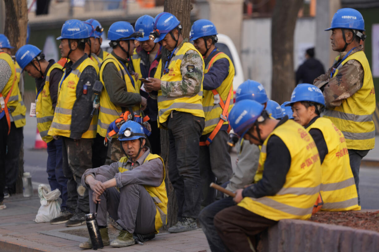 Workers wait for transport outside a construction site in Beijing, Tuesday, April 9, 2024. China&rsquo;s Finance Ministry has denounced a report by Fitch Ratings that kept its sovereign debt rated at A+ but downgraded its outlook to negative, saying in a statement that China&rsquo;s deficit is at a moderate and reasonable level and risks are under control.
